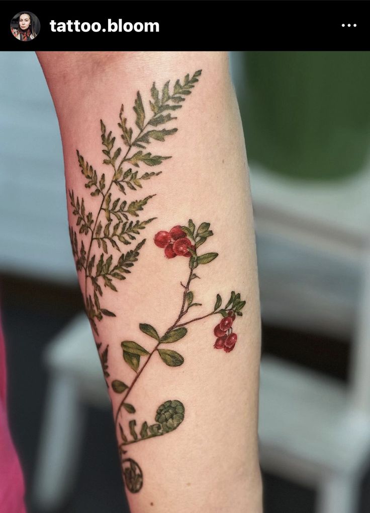 a woman's arm with flowers and leaves on it