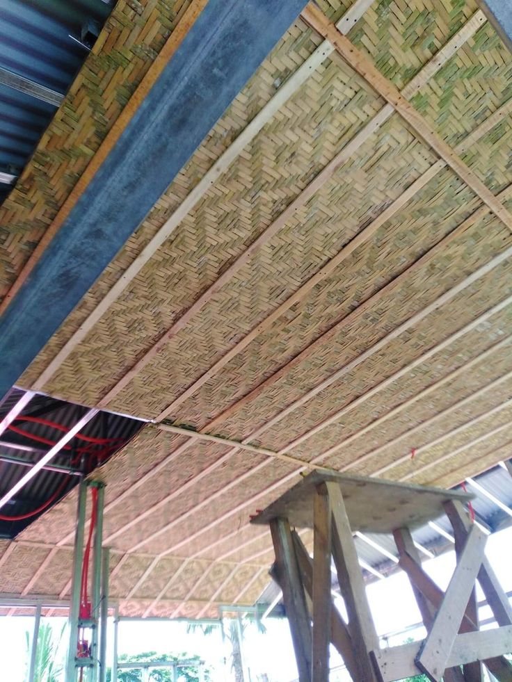 the inside of a building that is being constructed with bamboo rafters and wood beams