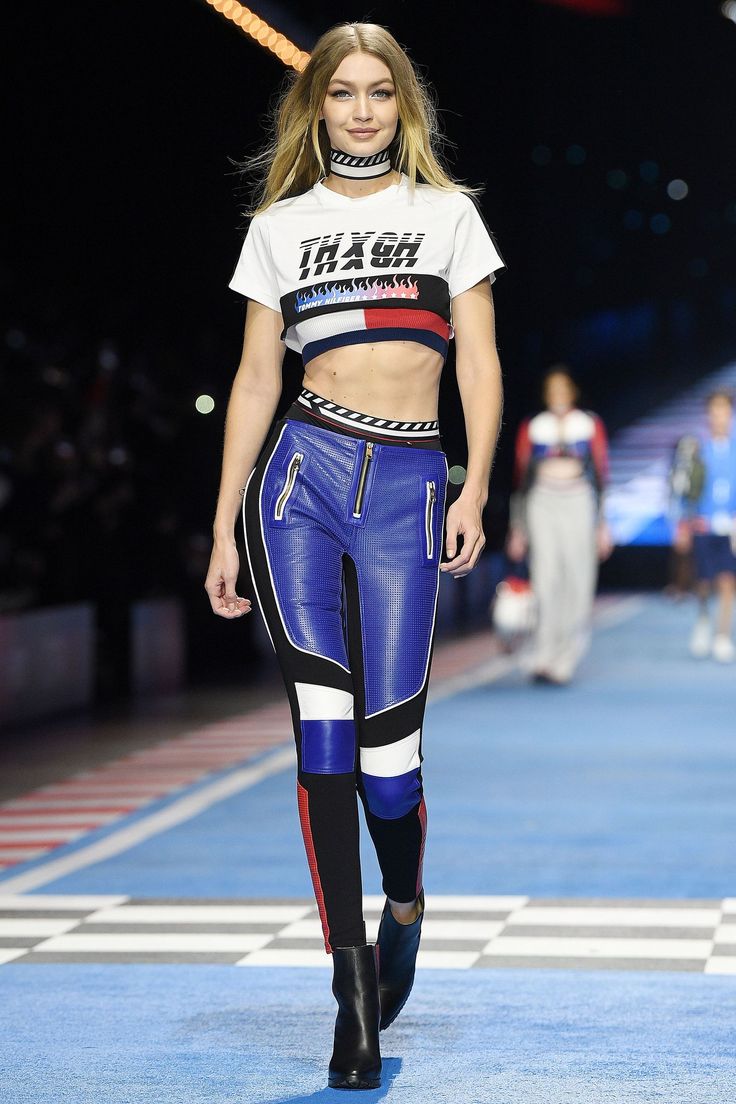 a model walks down the runway in blue pants