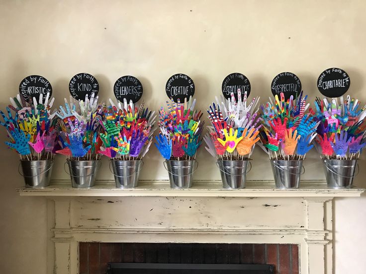 several buckets filled with colorful handprinted items on top of a fireplace mantel