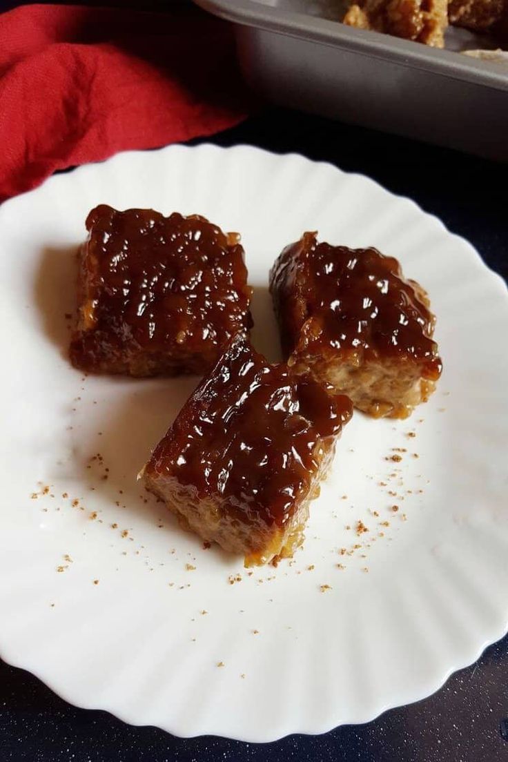 three pieces of caramel brownies on a white plate with sprinkles