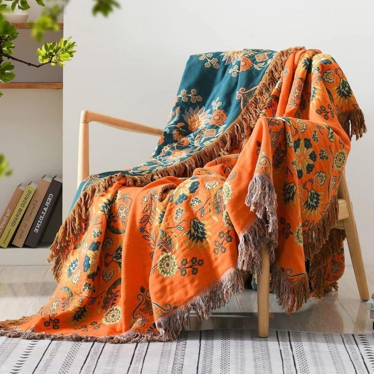 an orange and blue blanket sitting on top of a wooden chair