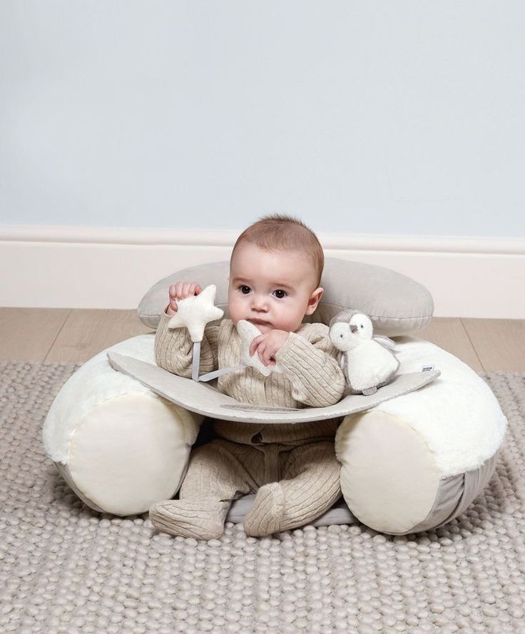 a baby sitting in a high chair with stuffed animals on it's back legs