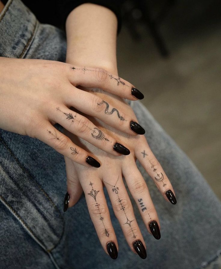 a woman's hand with tattoos on it and two fingers that have writing on them