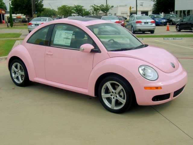 a pink car parked in a parking lot