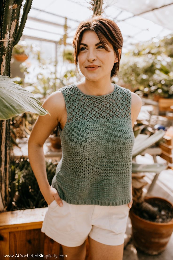 a woman standing in front of a potted plant with her hands on her hips