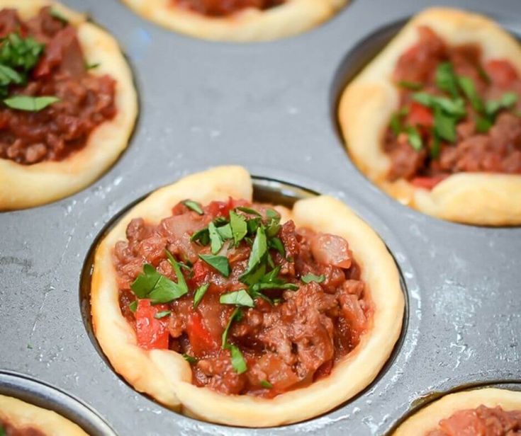 mini pizzas filled with meat and vegetables in a muffin tin