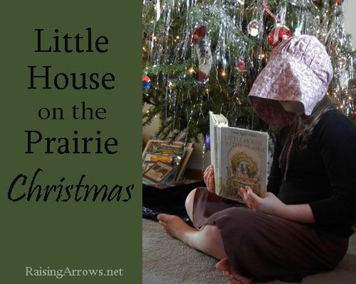 a woman sitting on the floor reading a book next to a christmas tree with lights