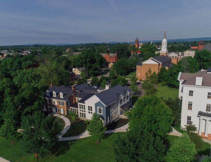 an aerial view of several houses in a neighborhood with trees and buildings on the other side