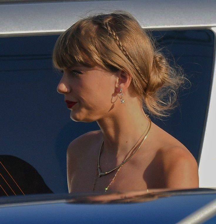 a woman in a dress is sitting in the back of a car