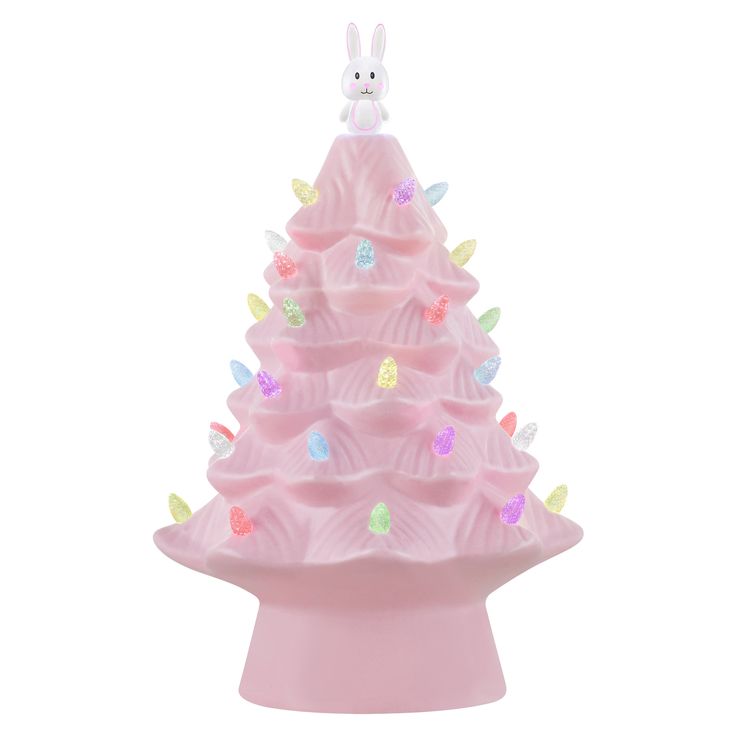 a pink ceramic christmas tree with lights on it's sides and a bunny figurine in the top