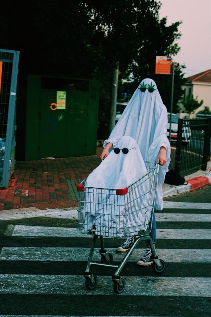 a person in a ghost costume pushing a shopping cart