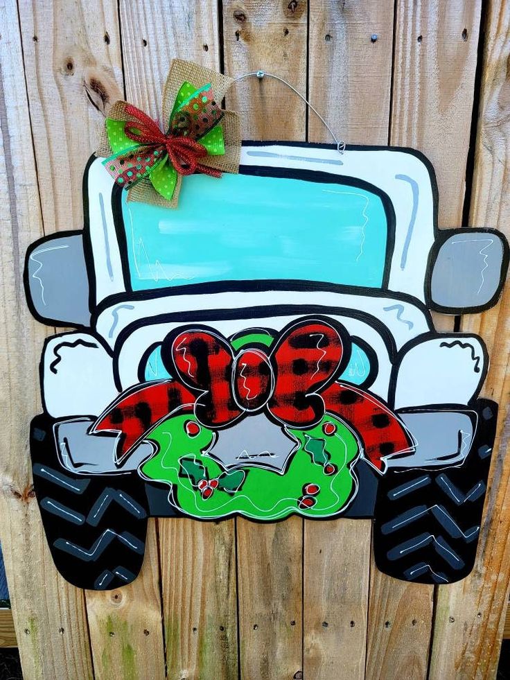 a sign that is on the side of a wooden fence with a green and red truck