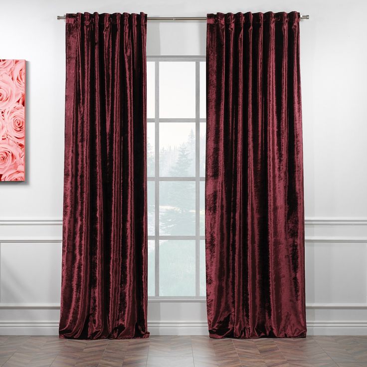 a large window with red curtains and pink roses on the curtain, in front of a white wall