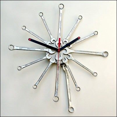 a clock made out of wrenches on a white surface with red and black handles