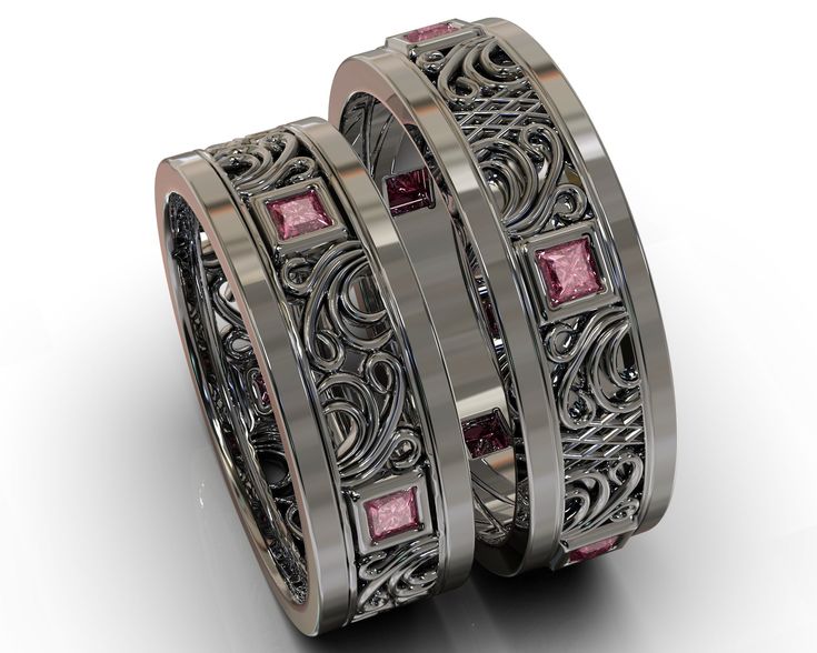 two wedding bands with pink stones on them