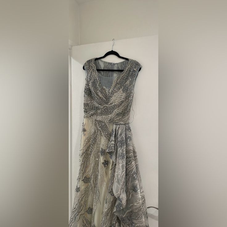 a dress hanging on a hanger in a room with white walls and flooring