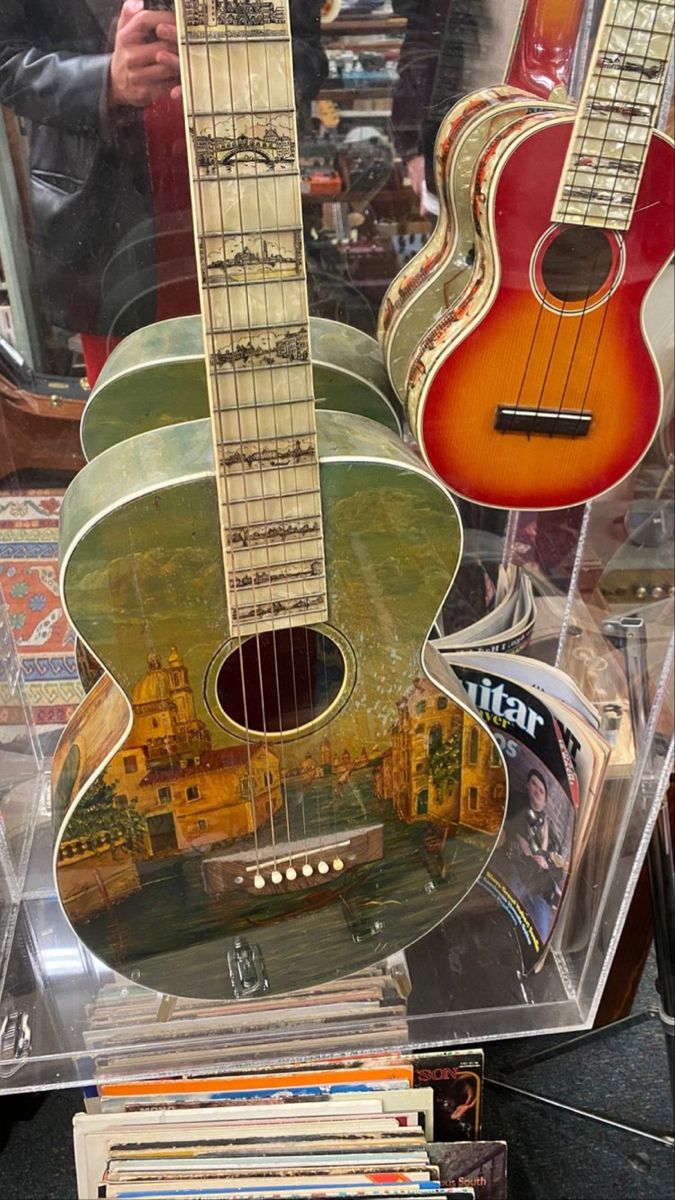 guitars are on display in a glass case