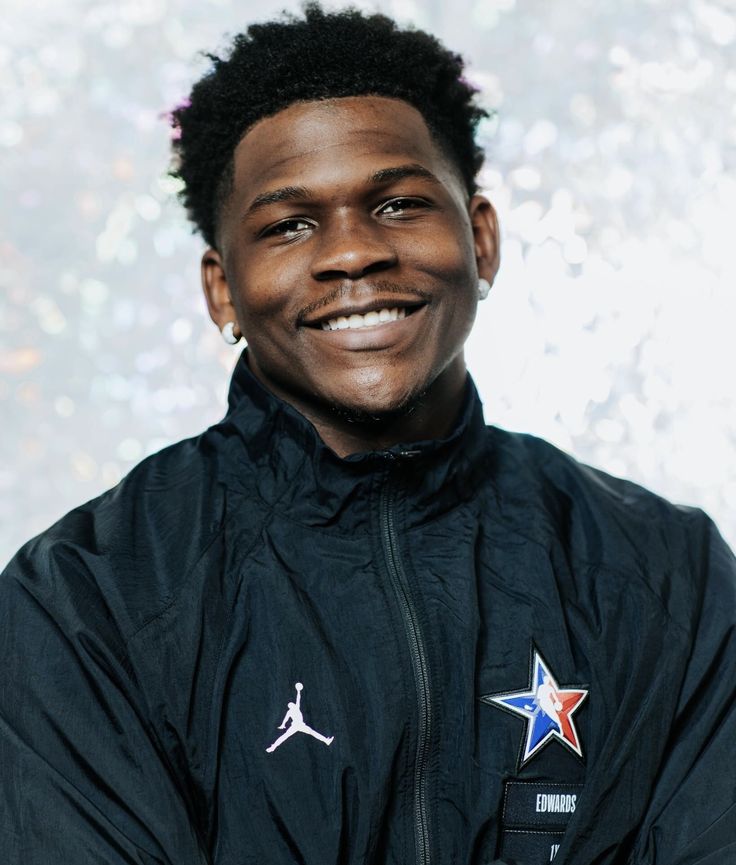 a young man wearing a black jacket with a star on the side and a white background