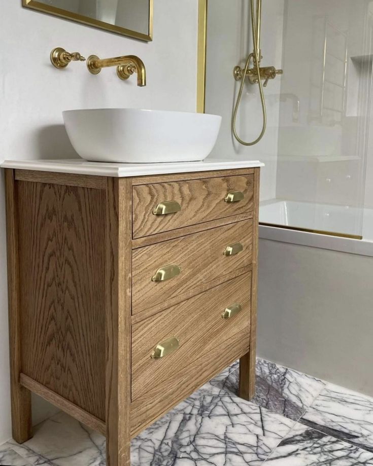 a white sink sitting on top of a wooden cabinet