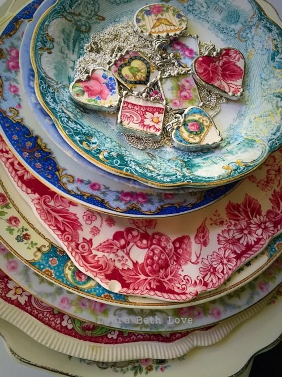 a stack of colorful plates with hearts and flowers on them, all stacked up next to each other