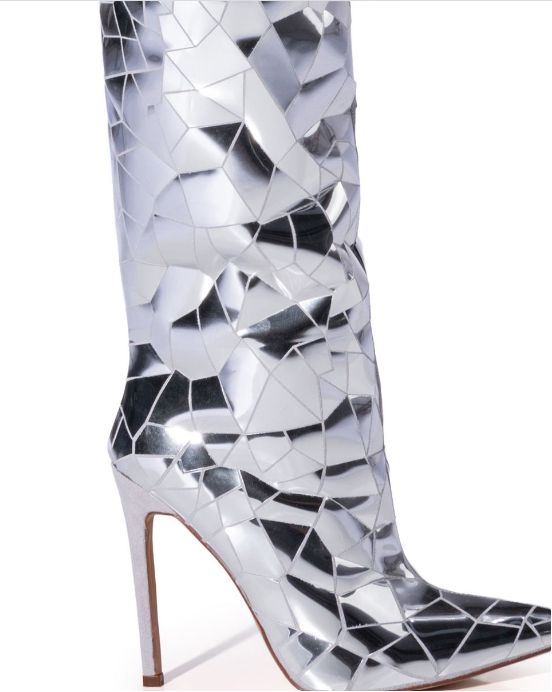 The RENAISSANCE TOUR Shattered Metallic Stiletto Boot In Silver features a faux suede upper, a thigh high shaft, a slim stiletto heel, a pointed toe silhouette, and an inner ankle zipper closure. Complete with reflective metallic crackle detailing throughout. Walk with the stars in these luxurious Shattered-Silver Stiletto Boots, crafted with a sleek, pointed toe and eye-catching shattered glass pattern. Fit for a diva, these over the knee boots are sure to make a statement with their shimmering Mirror Boots, Boutique Couture, Stiletto Boots, Stiletto Pumps, Shoe Closet, Long Boots, Black High Heels, Thigh High, Stiletto Heel