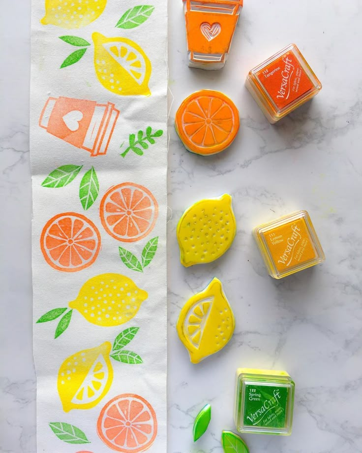 some oranges and lemons are on a towel next to soap cubes with green leaves