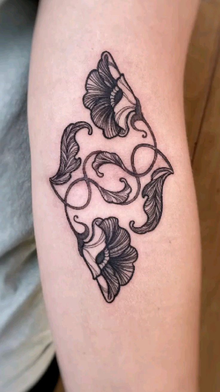 a black and white tattoo design on the thigh with butterflies in it's center