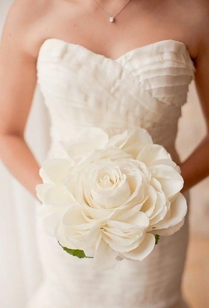 a woman holding a white flower in her hand