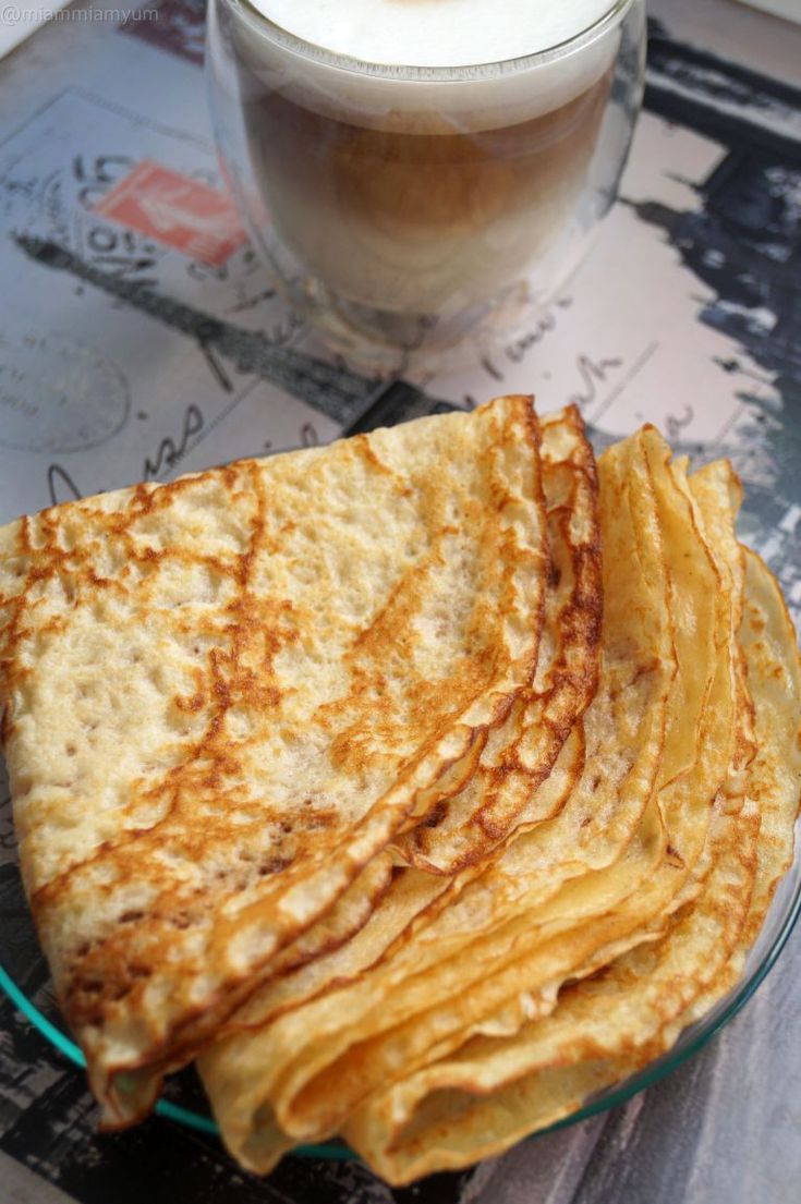 there is a glass plate with some food on it and a drink in the background