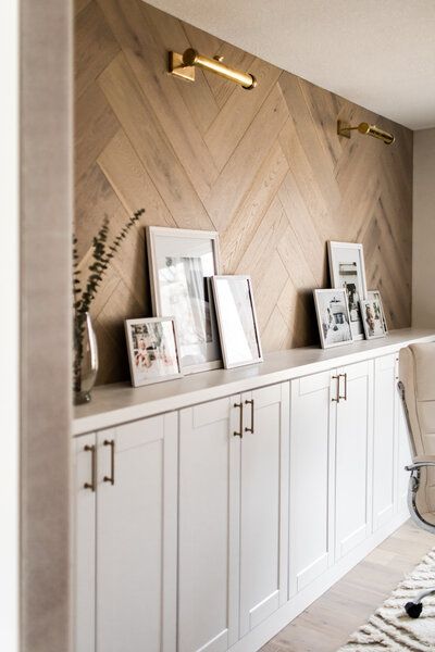 a room with white cabinets and pictures on the wall