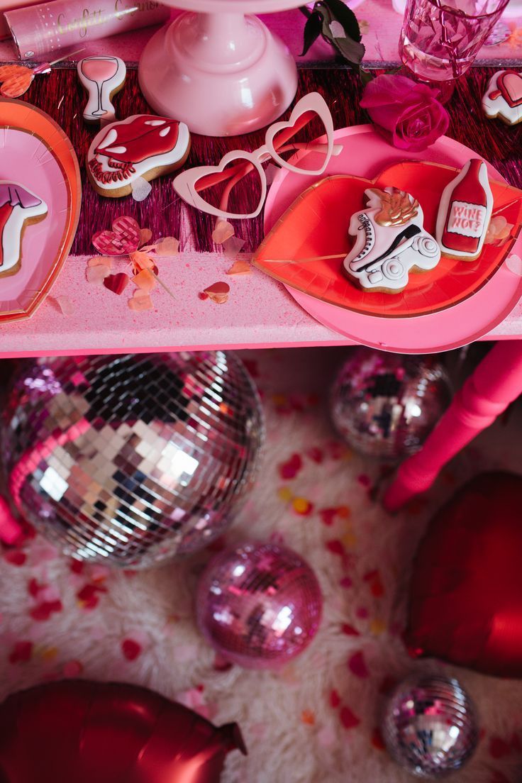 a table topped with lots of pink and red decorations