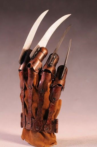 a leather glove with three knives sticking out of it's sides and the inside of its palm