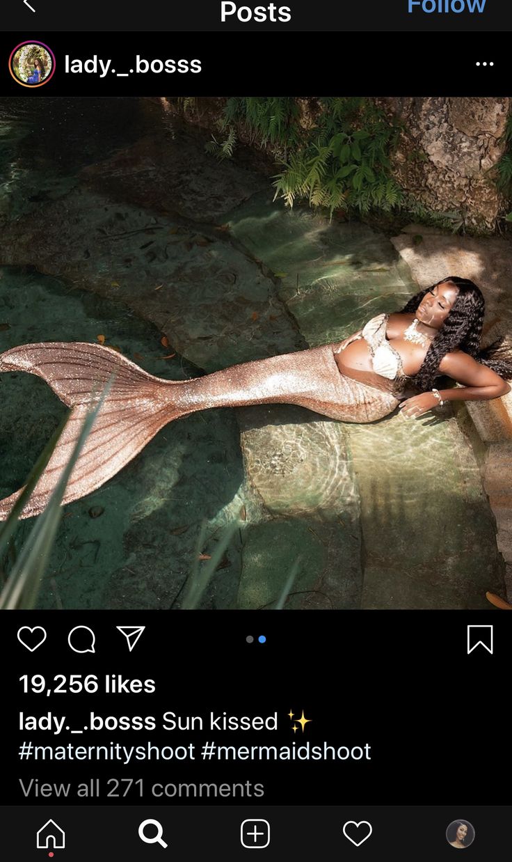 a woman is laying down on the ground with a mermaid tail in front of her