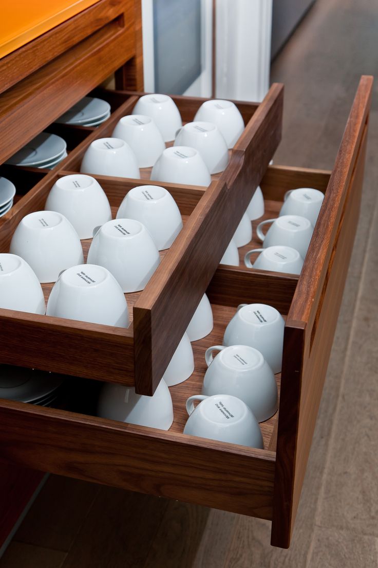 an open drawer with several cups in it