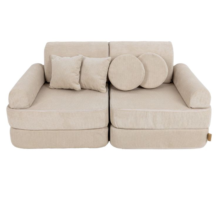 a large beige couch with pillows on it's back and two smaller ones sitting next to each other