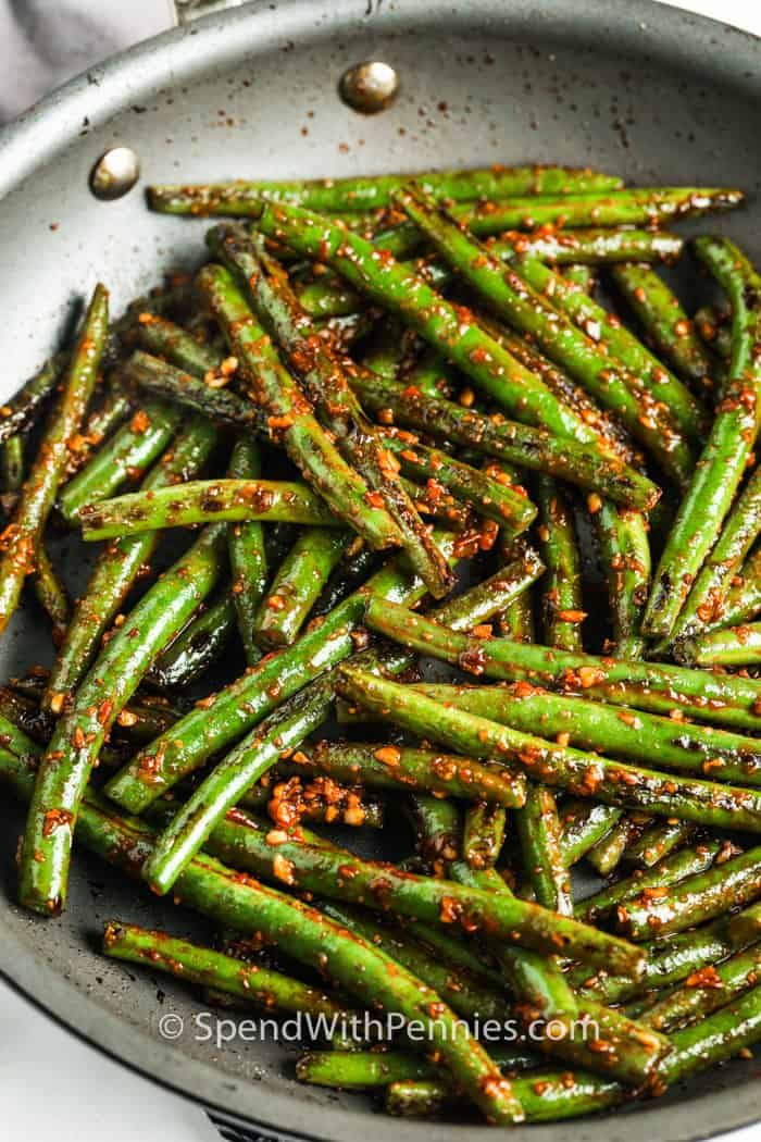 cooked green beans in a pan with seasoning