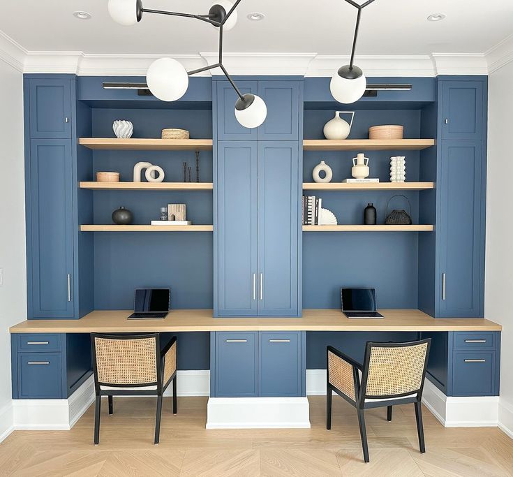 a room with blue cabinets and two chairs