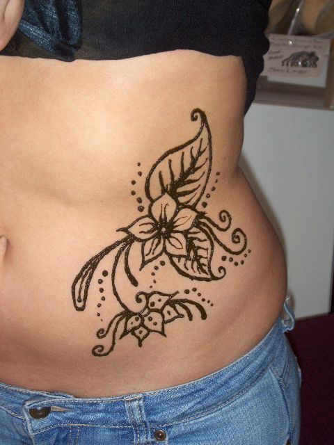 a woman's stomach with a tattoo design on the side and an open belly