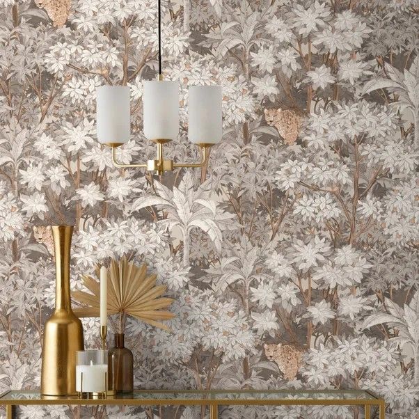 a wallpapered room with gold accents and white flowers on the wall, along with two lamps