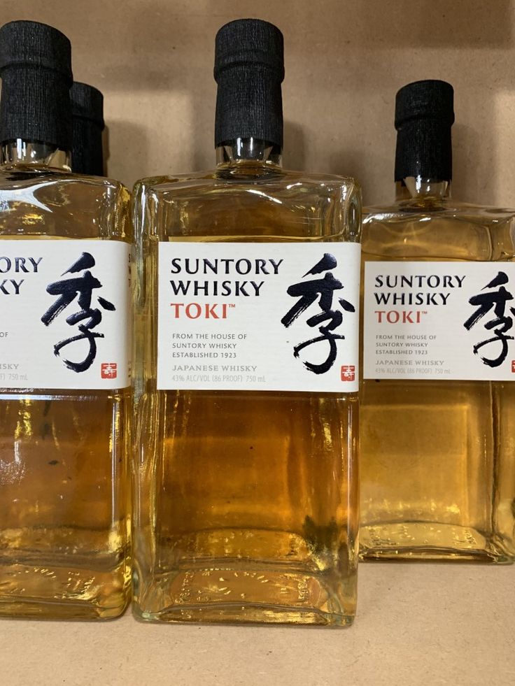 three bottles of suntory whisky sitting on a counter