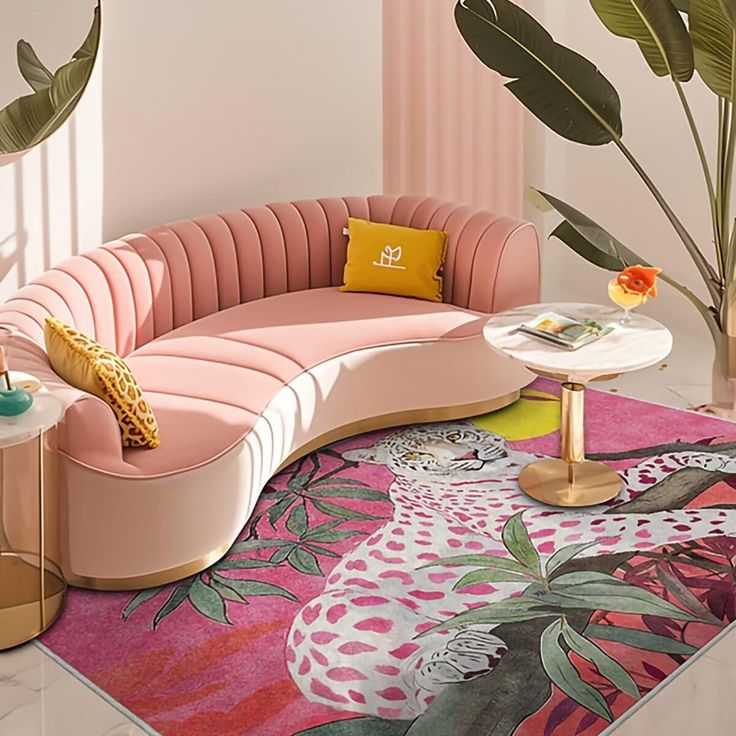 a pink couch sitting on top of a rug next to a table and potted plant