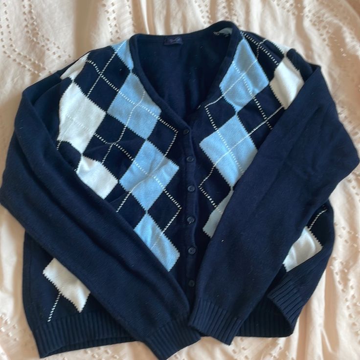 a blue and white sweater laying on top of a bed