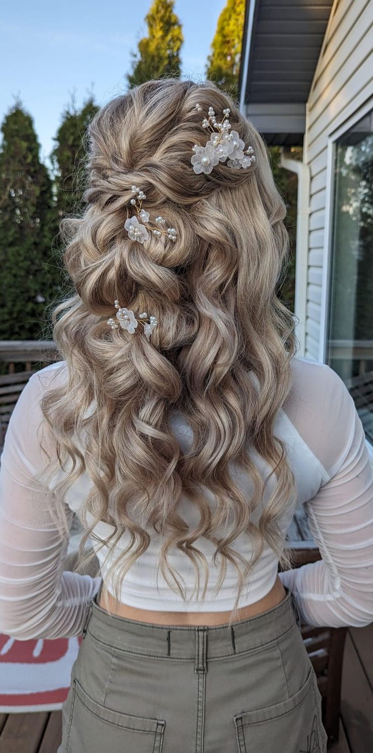 the back of a woman's head with long hair and flowers in her hair