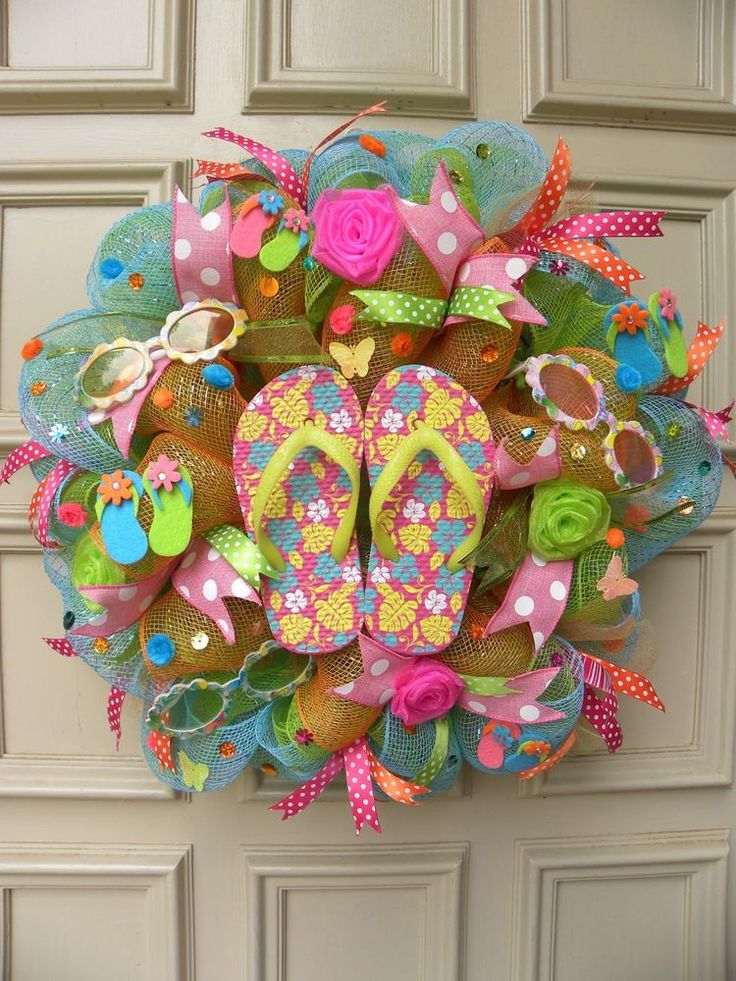 a colorful wreath with flip flops and sandals on it hanging from the front door