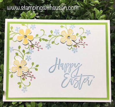 a happy easter card with flowers on the front and green foliage in the back ground