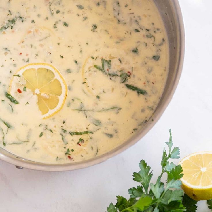 a pot full of soup with lemons and parsley