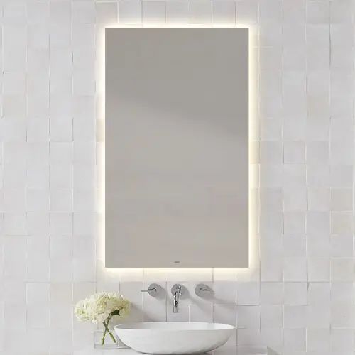 a white sink sitting under a bathroom mirror next to a wall mounted faucet