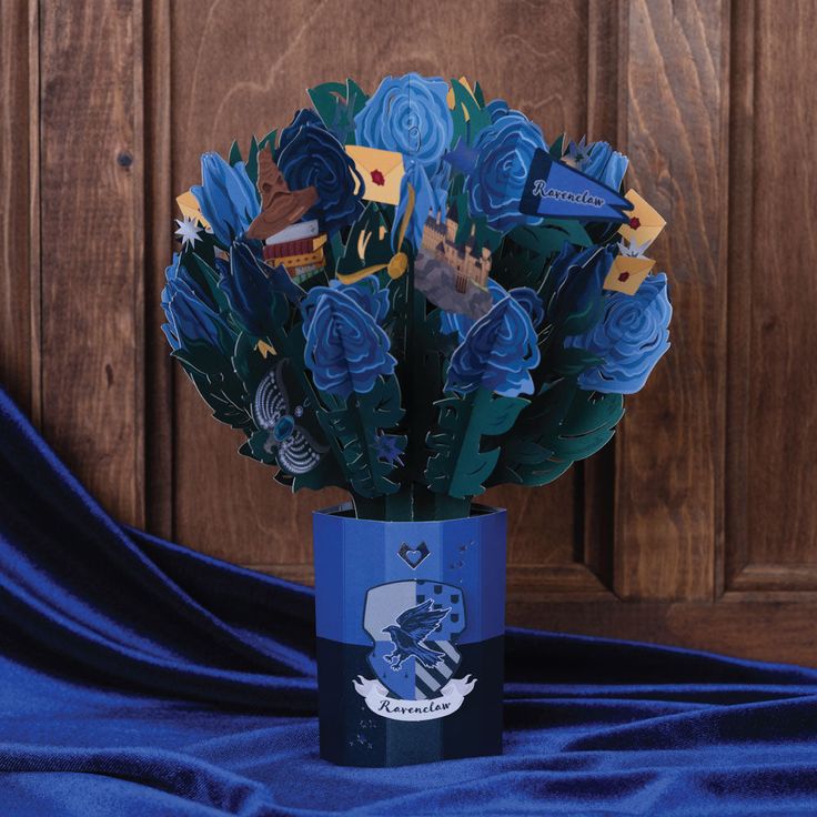 a vase filled with blue flowers on top of a blue cloth