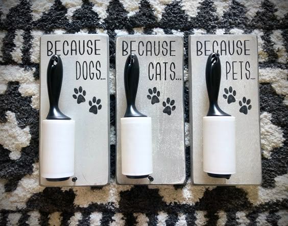 three black and white cat toothbrush holders on a carpeted area with dog paw prints